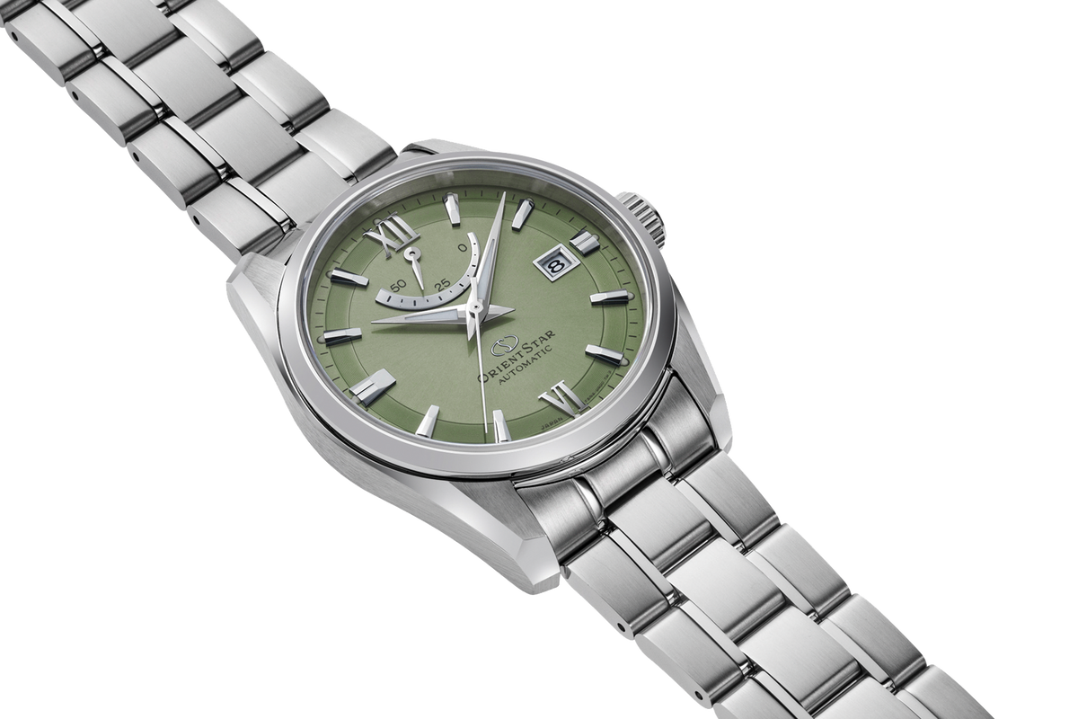 A stainless steel wristwatch with a green dial and a matching green subdial, set against a clean white background.
Orient Star RE-AU0107E